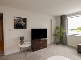 A living room with a television and lamp at 70 Deganwy Road in Deganwy