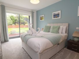 A bedroom with a bed and sliding doors to the garden at 70 Deganwy Road in Deganwy