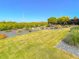 A garden with grass and plants at 70 Deganwy Road, Deganwy