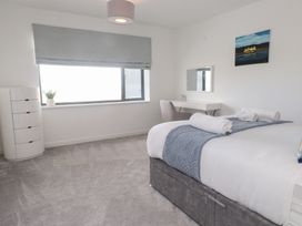 A bedroom with a bed and desk at Môr Glas in Deganwy