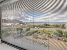 A view from a window showing the sea and landscape at Môr Glas in Deganwy