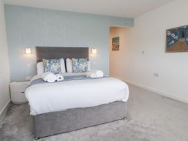 A bedroom with a bed and nightstand at Môr Glas in Deganwy