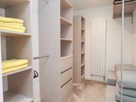 A bedroom with shelves and yellow towels at Môr Glas in Deganwy
