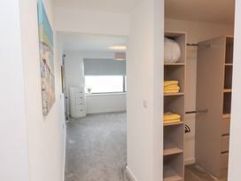 A bedroom with a closet and light fixture at Môr Glas Deganwy