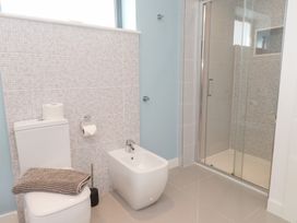 A bathroom with a toilet, bidet, and shower at Môr Glas, Deganwy