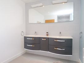 A bathroom with a sink and mirror at Môr Glas in Deganwy