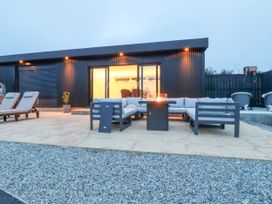 An outdoor patio with seating and a fire pit at The Lake Boat exclusive retreat Black Cross near St Columb Major