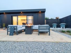 An outdoor patio with a fireplace and seating at The Lake Boat exclusive retreat Black Cross near St Columb Major