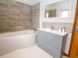 A bathroom with a bathtub and sink at Byron’s Retreat in Crantock