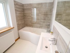 A bathroom with a bath tub and sink at Byron’s Retreat in Crantock