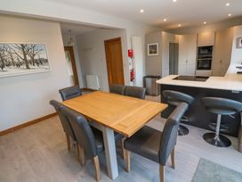 A dining room with a wooden table and chairs at Byron’s Retreat in Crantock