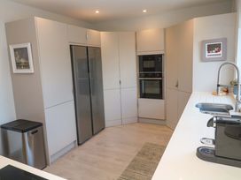 A kitchen with cabinets, refrigerator and oven at Byron’s Retreat in Crantock