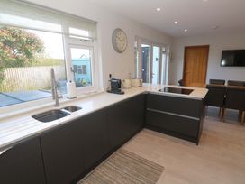 A kitchen with sink, counter, and dining area at Byron’s Retreat in Crantock
