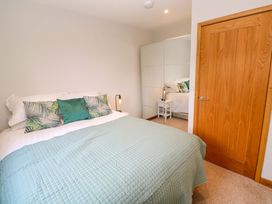 A bedroom with a bed and wardrobe at Byron’s Retreat in Crantock