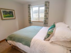 A bedroom with a bed and window at Byron’s Retreat Crantock