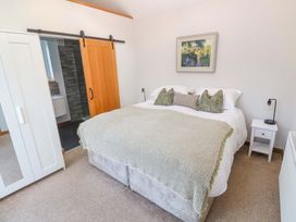 A bedroom with a bed and nightstand at Byron’s Retreat in Crantock