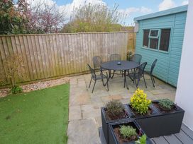 A garden with a table and chairs at Byron’s Retreat in Crantock