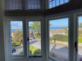 A view from a window showing trees and houses by the ocean at Purbeck Vista in Swanage