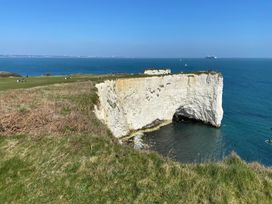 A cliff overlooking the ocean with people in the background at Purbeck Vista in Swanage