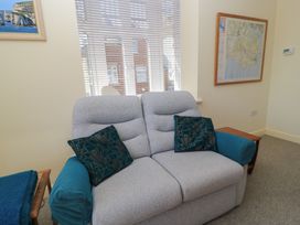 A living room with a sofa and a map on the wall at Purbeck Vista in Swanage