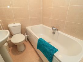 A bathroom with a bath tub, toilet, and sink at Purbeck Vista in Swanage