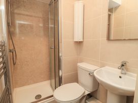 A bathroom with shower, toilet, sink and mirror at Purbeck Vista in Swanage