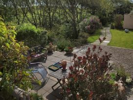 A garden with seating and plants at The Pink House in Nine Wells near Solva
