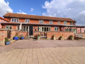 A brick building with windows and plants at Churn House in Ipswich