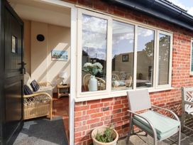 A sunroom with seating and a table at Churn House in Ipswich