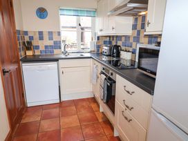 A kitchen with appliances and cabinets at Churn House in Ipswich