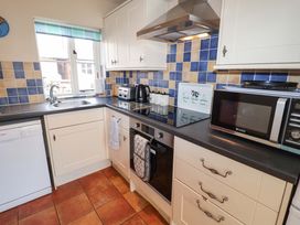 A kitchen with modern appliances and tiled backsplash at Churn House in Ipswich