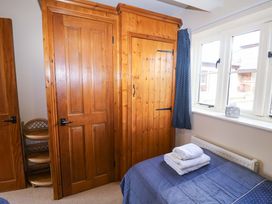 A bedroom with wardrobe, shelves, and bed at Churn House in Ipswich