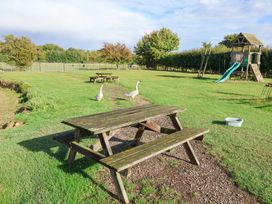 An outdoor area with tables and a playground at Churn House in Ipswich