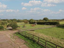 An outdoor area with a playground and picnic table at Wheelwright's Cottage in Ipswich