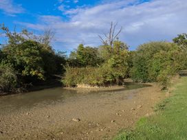 A natural landscape with a riverbank and vegetation at Wheelwright's Cottage in Ipswich