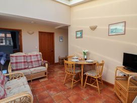 A dining room with a sofa and a table at Wheelwright's Cottage in Ipswich