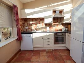 A kitchen with cabinets and appliances at Wheelwright's Cottage Ipswich