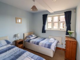A bedroom with two beds and a window at Wheelwright's Cottage Ipswich