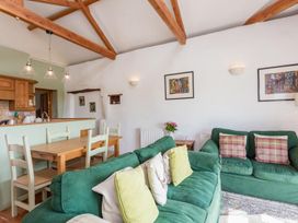 A living room with a sofa and dining area at Billy's Barn in Bradworthy