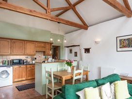 A kitchen with a dining area and washing machine at Billy's Barn in Bradworthy