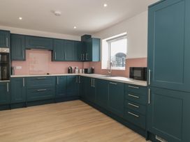 A kitchen with blue cabinets and a sink at 3 The Stables Highbridge