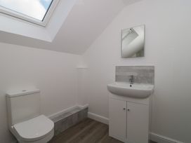 A bathroom with a toilet, sink, and mirror at 3 The Stables in Highbridge