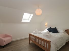 A bedroom with a bed and chair at 3 The Stables Highbridge
