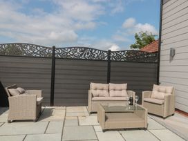 An outdoor seating area with a sofa and chairs at 3 The Stables Highbridge