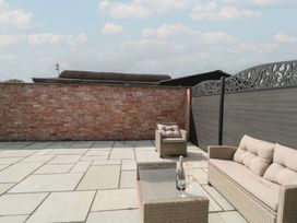 Outdoor seating area with a glass table and wine glasses at 3 The Stables Highbridge