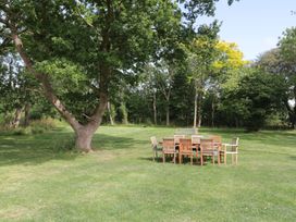 An outdoor area with a dining table and chairs at 3 The Stables Highbridge
