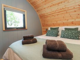 A bedroom with a bed and pillows and towels at Barley near Nelson