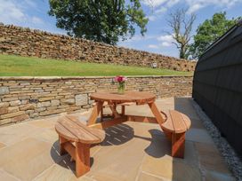 An outdoor area with a wooden table and benches at Barley near Nelson