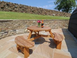 A picnic table with a flower vase and champagne at Black Moss in Nelson