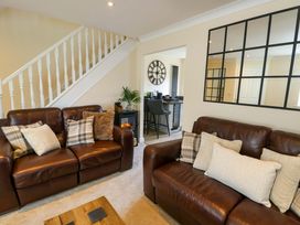 A living room with sofas and a staircase at 20 Cysgod Y Bryn Rhos-On-Sea